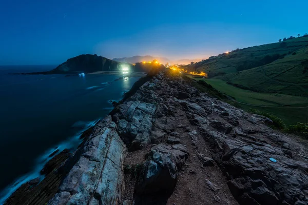 Vista nocturna del acantilado con marea baja y la luz de la luna llena en Zumaia —  Fotos de Stock