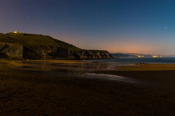 Vista nocturna de la playa de Zumaia con marea baja y luz de luna llena —  Fotos de Stock