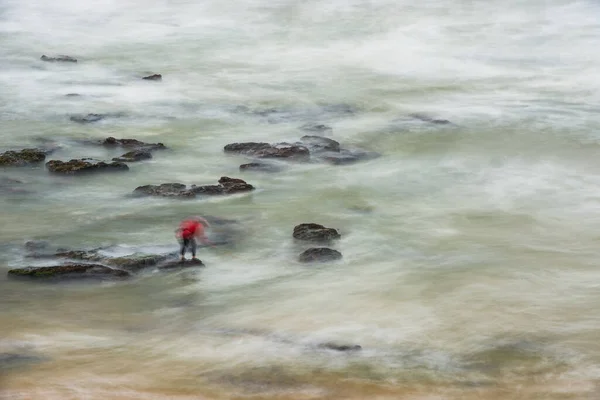 Fotografía de larga exposición de un pescador de mariscos trabajando en las rocas en la playa de Seixo, Torres Vedras —  Fotos de Stock