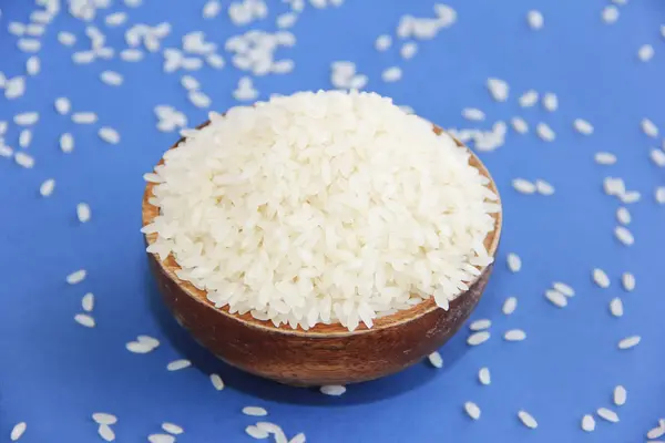 Натуральный свежий белый круглый рис в декоративной деревянной тарелке — стоковое фото