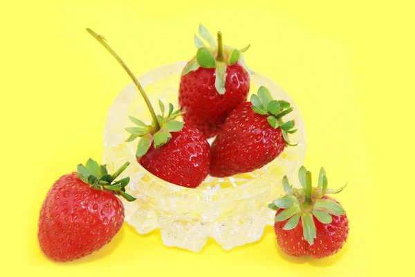 Červená přírodní čerstvé jahody v dekorativním skleněném talíři na žlutém pozadí — Stock fotografie