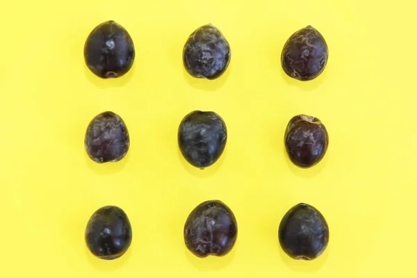 Natural fresh black olives on a yellow background — Stock Photo, Image