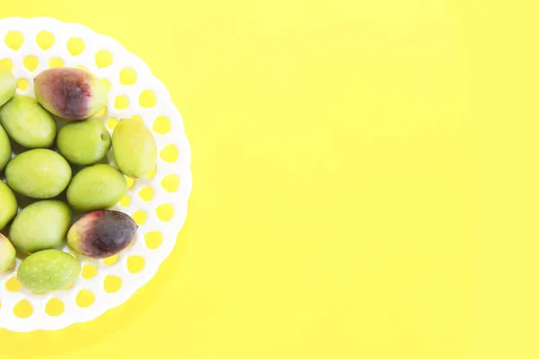 Natürliche Grüne Und Braune Oliven Einem Dekorativen Teller Auf Gelbem — Stockfoto