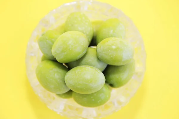 Přírodní kulaté zelené olivy v dekorativním skleněném talíři — Stock fotografie