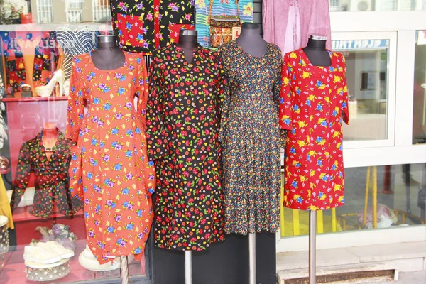 multi-colored women\'s dresses with a pattern of flowers on mannequin