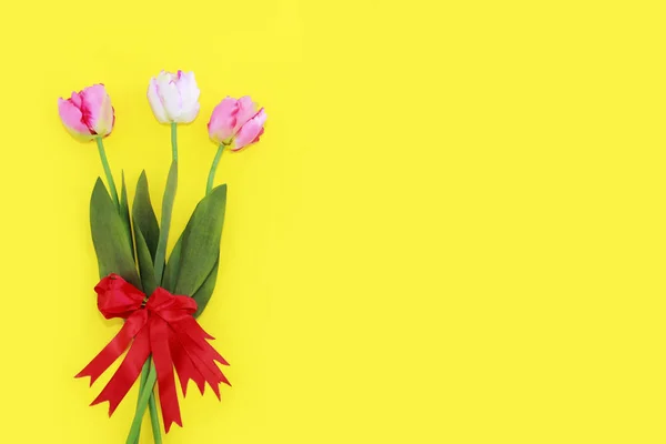 Ramo festivo de tulipanes rosados naturales con una cinta roja — Foto de Stock