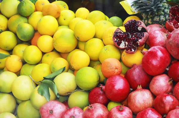 Natural fresh fruits yellow lemons, oranges and red pomegranates — Stock Photo, Image