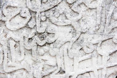 Doğu şekilli hiyeroglifleri tasvir eden gri taş bir duvarın parçası.