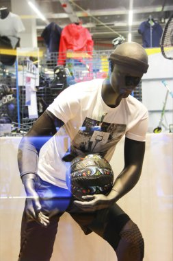 Bir vitrinde çok renkli giysiler içinde manken.