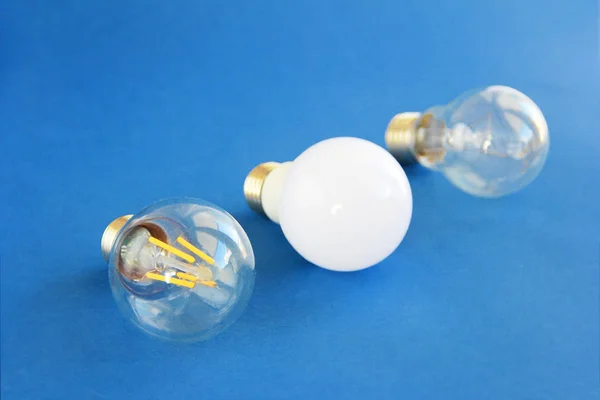 Glass round electric lamps for lighting on a blue background — Stockfoto