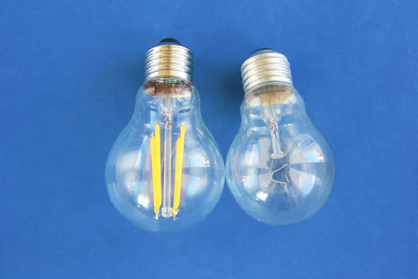 Γυάλινοι στρογγυλοί ηλεκτρικοί λαμπτήρες για φωτισμό σε μπλε φόντο — Φωτογραφία Αρχείου