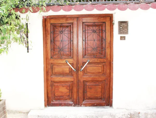 Porte a battente in legno nell'edificio con motivi decorativi e accessori per l'apertura — Foto Stock