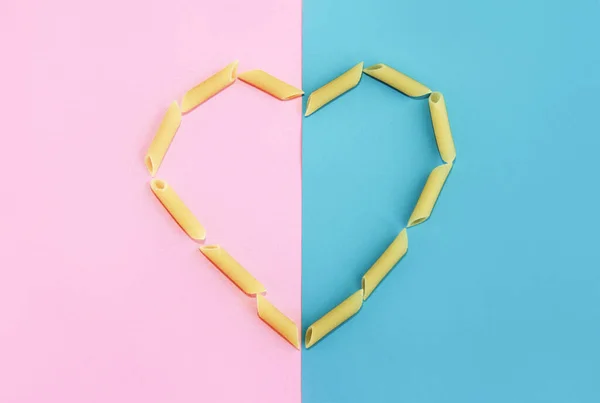 Herz Aus Natürlichen Gelben Langen Nudeln Auf Rosa Blauem Hintergrund — Stockfoto