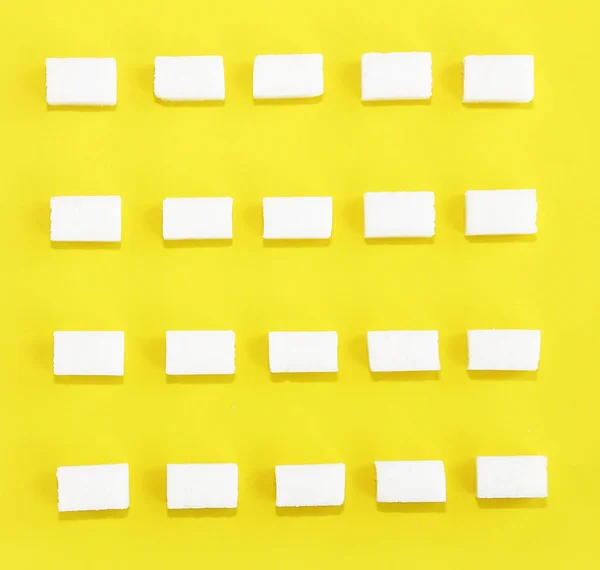Čtvercové kostky sladkého bílého rafinovaného cukru na žlutém pozadí — Stock fotografie