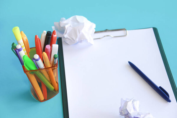 stationery pens, sheets of crumpled white paper on a background of paper holder