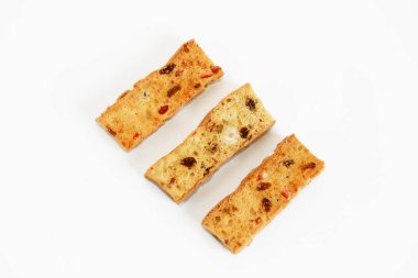 Beyaz arka planda meyve dilimleri olan beyaz ekmek krakerleri.