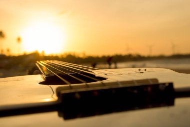 Tocar violo na praia no final do dia