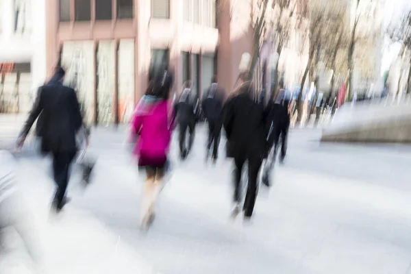 Stedelijke beweging, mensen lopen in de stad, bewegingsonscherpte, zoom-effect — Stockfoto