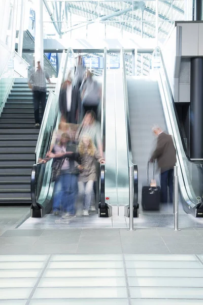 Group of real people on escalator, airport interior — Stock Photo, Image