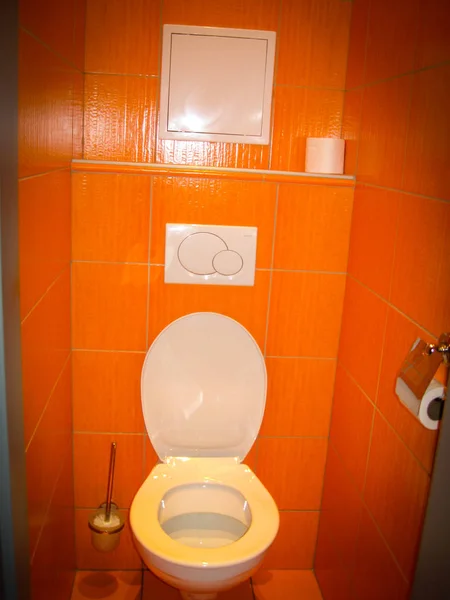 Weiße Toilette in einem schönen orangefarbenen Toilettenraum — Stockfoto