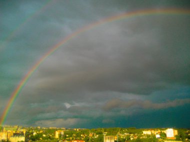 Fırtına sonrası şehir manzarası. Şehrin üzerinde çifte gökkuşağı