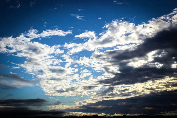 El cielo cubierto de nubes oscuras y blancas al atardecer . — Foto de Stock