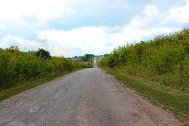 Eski asfalt asfaltlarla kaplı ıssız, kalitesiz bir arazi yolu.