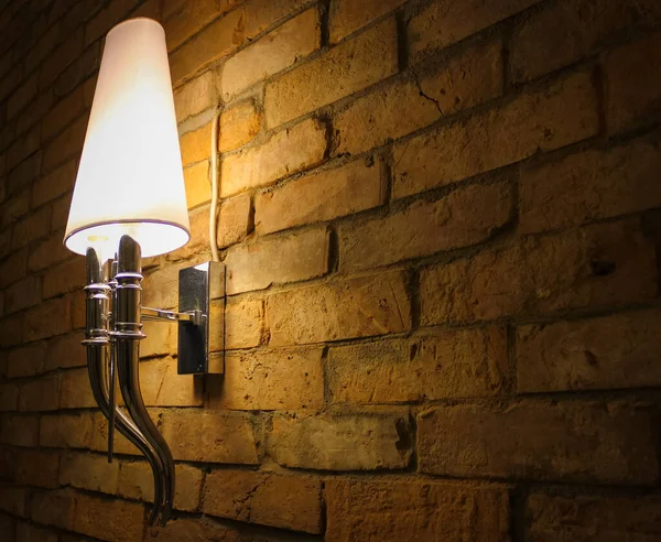 レンガの壁にある古い電気ランプは部屋を照らす ストック写真