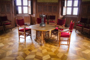 Bojnice, Slovakya - 04 Ekim 2014: Ortaçağ kalesinde ahşap duvarlı bir oda. Ortada bir masa ve sandalyeler var. Odanın da şöminesi var.. 