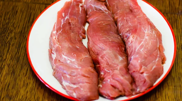 Drei Große Stücke Rohes Schweinefleisch Liegen Auf Einem Runden Teller — Stockfoto