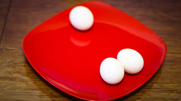 三つのゆで卵が赤の四角形の皿の上に立つ — ストック写真