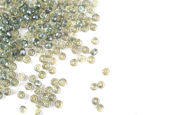 Green beads are scattered on a white background