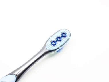 Beyaz zemin üzerinde mavi plastik diş fırçası.