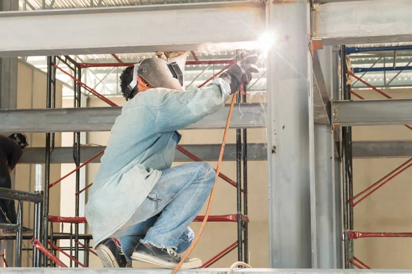 adam bir kaynak makinesi ile bir metal kaynak.