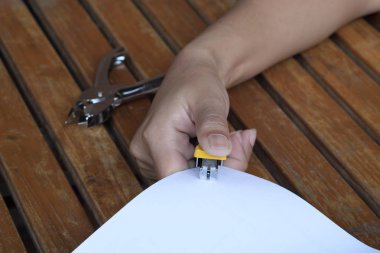 Elini tut zımba yaprak kağıt closeup bağlama.