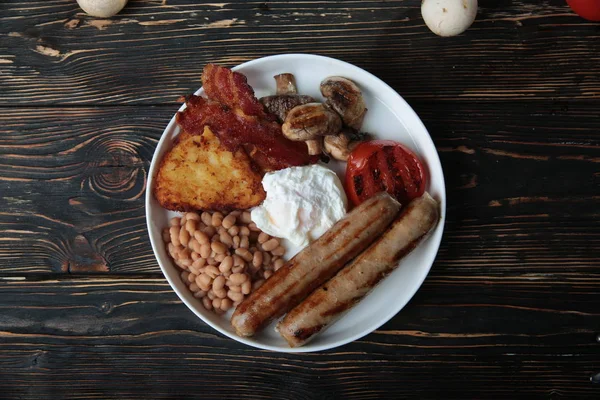 Sağlıklı tam İngiliz kahvaltısı - tabak haşlanmış yumurta, sosis, mantar, tost ve pastırma