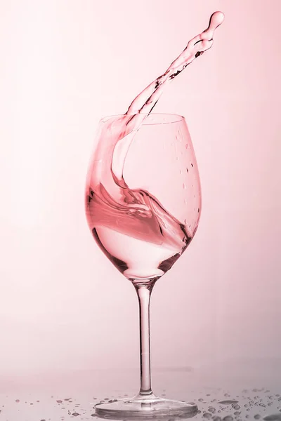 Water spatten uit een hoog glas wijn. — Stockfoto