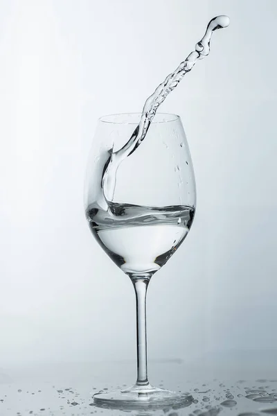 Νερό πιτσίλισμα από ένα ψηλό ποτήρι κρασί. — Φωτογραφία Αρχείου
