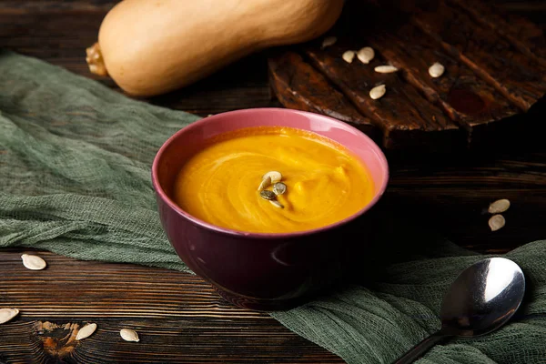 Krem koyu ahşap arka plan üzerinde kabak ve havuç çorbası