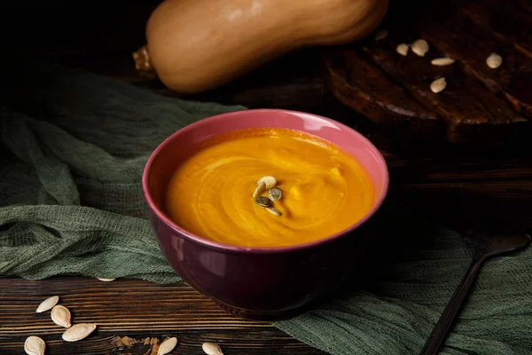 Krem koyu ahşap arka plan üzerinde kabak ve havuç çorbası