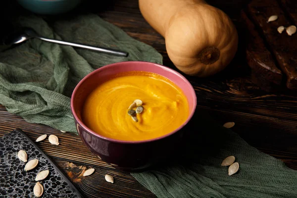 Krem koyu ahşap arka plan üzerinde kabak ve havuç çorbası