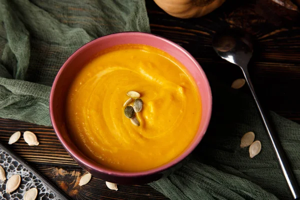 Krem koyu ahşap arka plan üzerinde kabak ve havuç çorbası