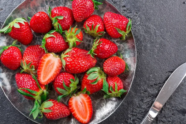 Taze çilek plaka koyu arka plan.