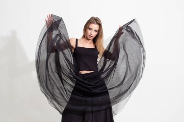 Tişörtlü ve havada süzülen siyah etekli kız. Moda çekimi.