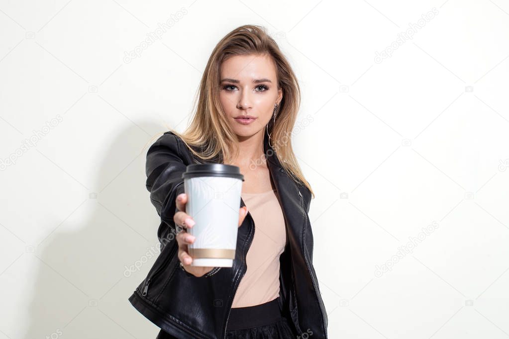 Girl shows plastic coffee cup on white background