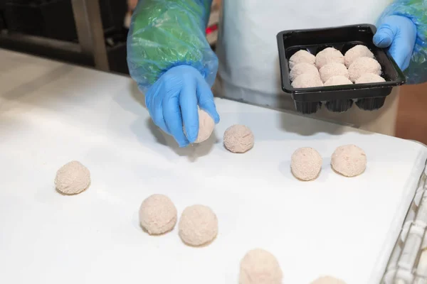 The process of packing cutlets on the production line. Factory for the production of food from meat