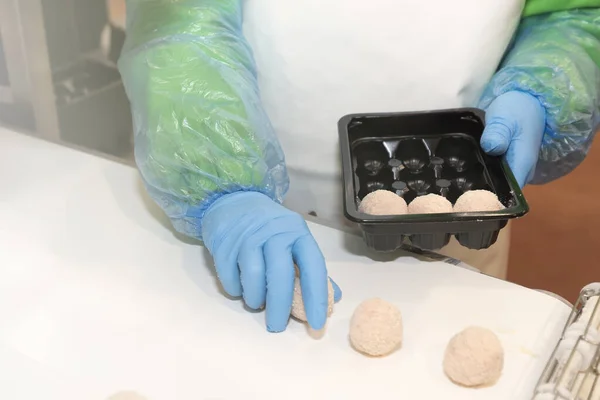 The process of packing cutlets on the production line. Factory for the production of food from meat