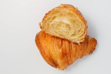 Taze pişmiş geleneksel kruvasan iki parçaya bölünmüş.