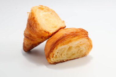 Taze pişmiş geleneksel kruvasan iki parçaya bölünmüş.