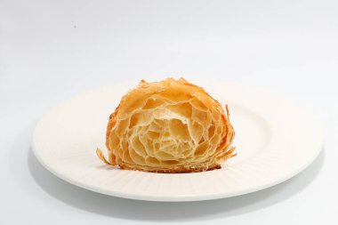 Taze pişmiş geleneksel kruvasan iki parçaya bölünmüş.